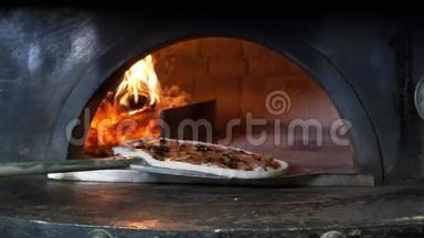 意大利披萨和西红柿是在烤箱里煮的，餐馆厨师在餐馆的木头烤箱里拿披萨。